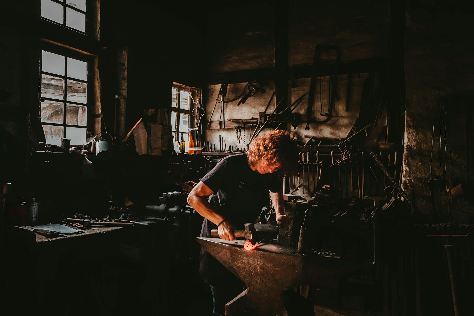 A blacksmith striking hot steel at the forge